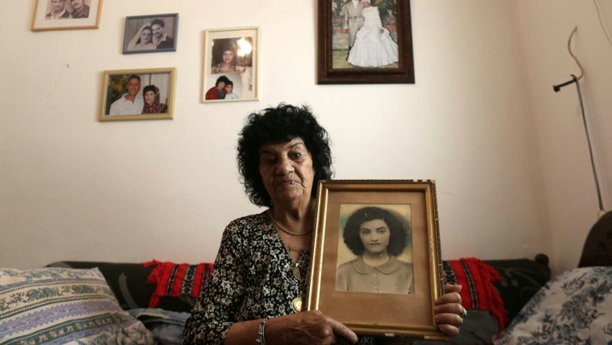 Shoshana Dugma, 83 ans, pose avec un portrait d'elle plus jeune, le 27 juin 2016 à son domicile d'Elyakhin, en Israël