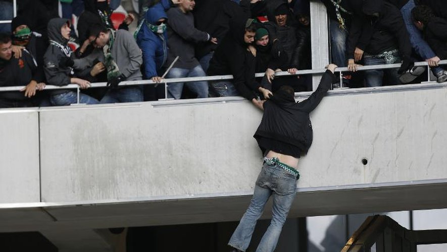 Un supporteur stéphanois suspendu au parapet du parcage visiteurs lors d'incidents pendant Nice - Saint Etienne, le 24 novembre 2013 à l'Allianz Riviera