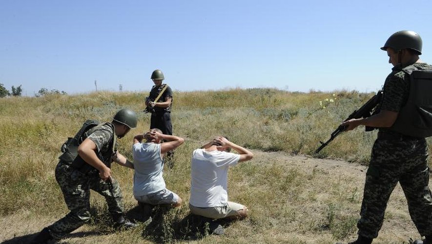 Des gardes ukrainiens contrôlent des personnes qui ont franchi illégalement la frontière avec la Russie, le 15 août 2014 près de la petite ville de Novoazovsk (région de Donetsk)