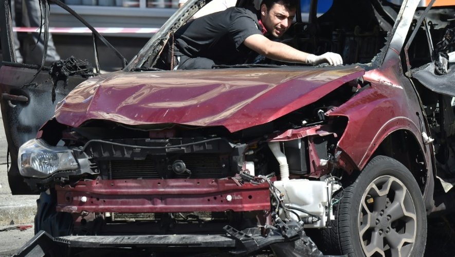 Les policiers et experts ukrainiens examinent la voiture calcinée de Pavel Cheremet, tué dans une explosion le 20 juillet 2016 à Kiev