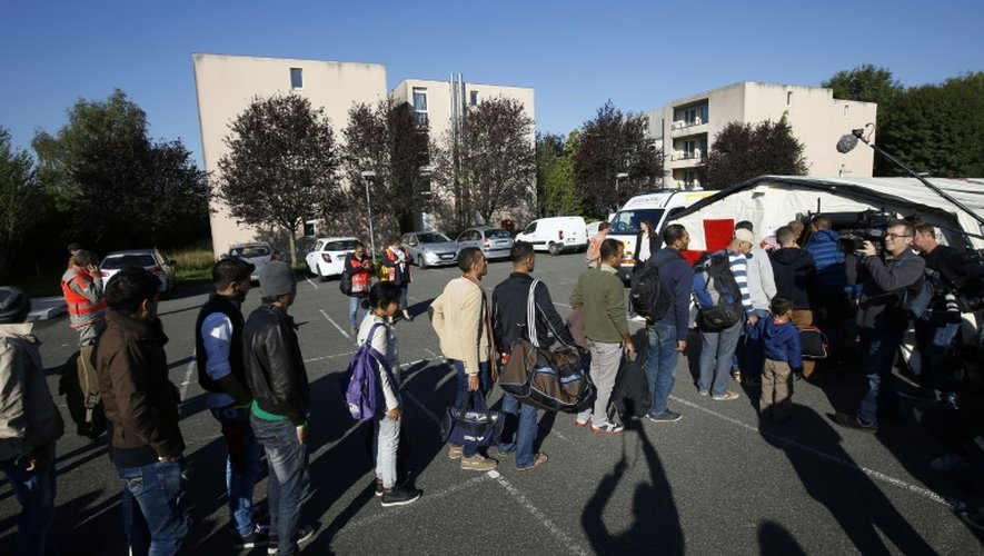 Des migrants syriens, érythréens et irakiens font la queue pour obtenir une collation devant une tente de la Croix-Rouge à leur arrivée à Champagne-sur-Seine, en Seine-et-Marne