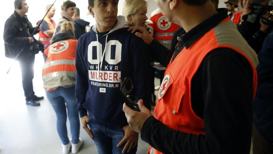 Un membre de la Croix-Rouge parle avec un des 93 migrants arrivés à Champagne-sur-Seine, en Seine-et-Marne