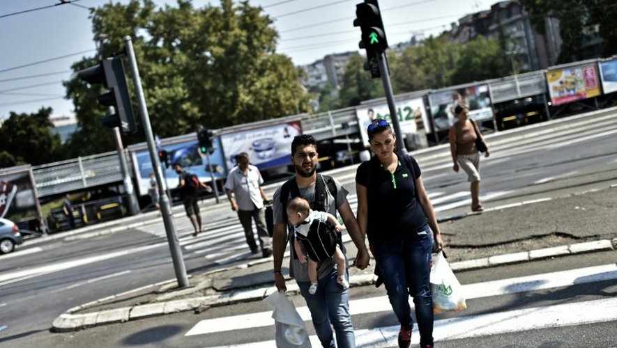 Les réfugiés irakiens Ahmad, Alia et leur bébé Adam marchent dans les rues de Belgrade, le 1er septembre 2015