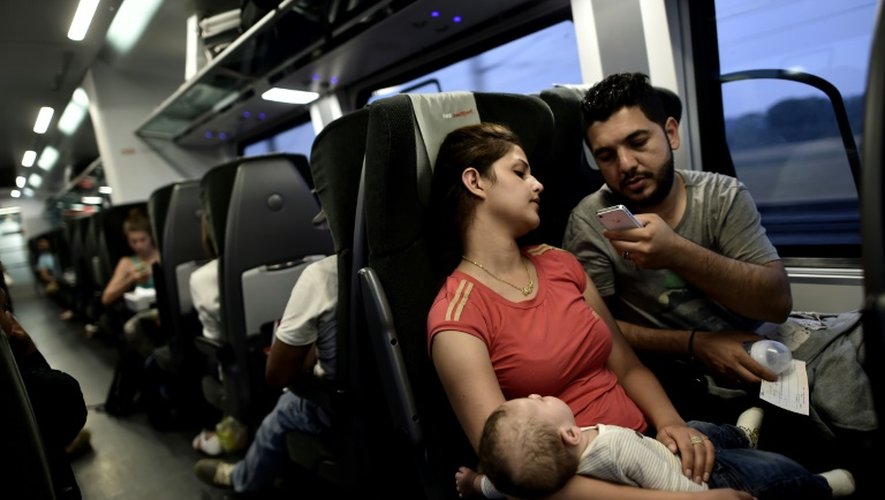 Les réfugiés irakiens Ahmad, Alia et leur bébé sont dans un train qui les emmène en Allemagne depuis l'Autriche, le 3 septembre 2015