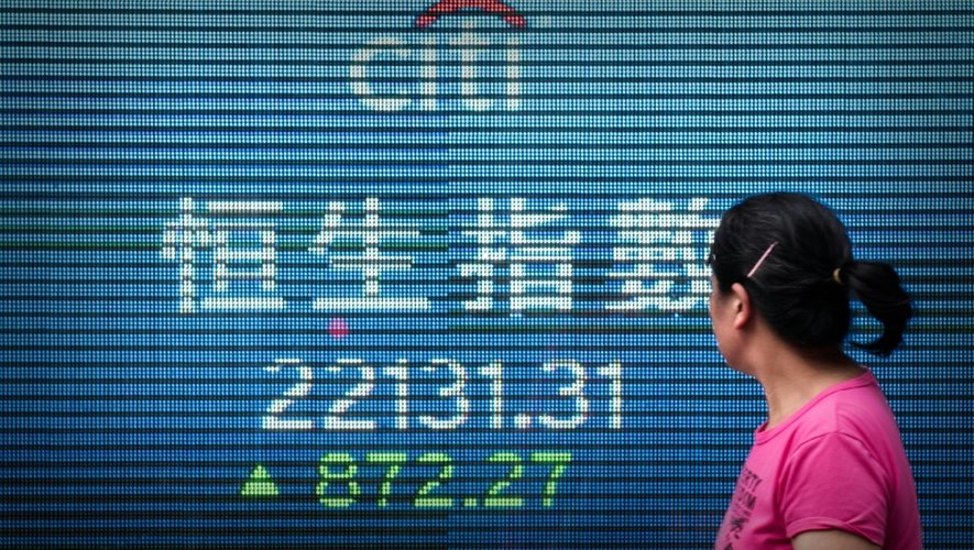 Une femme regarde un tableau d'indices boursiers, le 9 septembre 2015 à Hong Kong