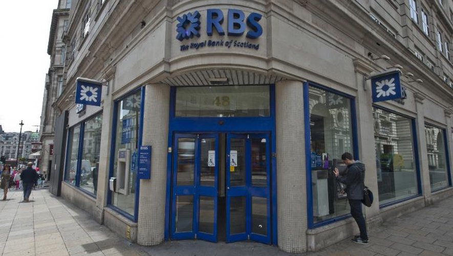 Un homme utilise le distributeur automatique d'une banque RBS (Royal Bank of Scotland), le 14 juin 2013 à Londres