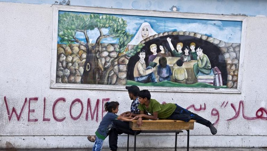 Des enfants palestiniens jouent devant l'école de l'ONU à Gaza City, le 15 août 2014
