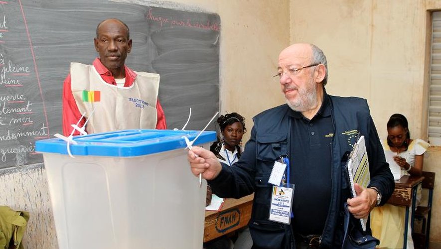 Louis Michel, chef des observateurs européens (d), pose des scellés sur une urne, à l'issue des législatives, le 24 novembre 2013 à Bamako, au Mali
