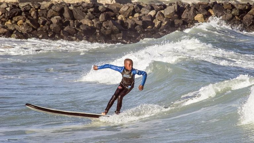 Un jeune garçon participe le 7 août 2014 sur la plage de Monwabis dans la banlieue du Cap aux activités de Waves for Change ("des vagues pour changer"), une ONG fondée par le surfeur britannique Tim Conibear