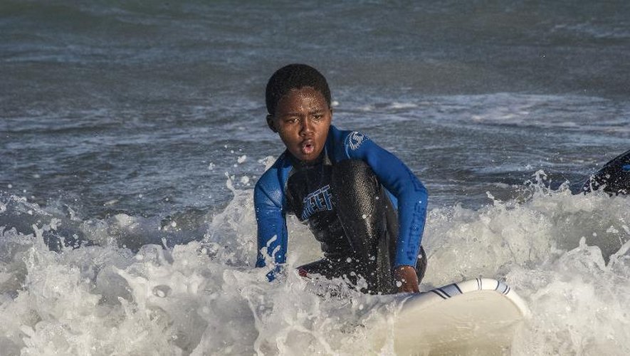 Un jeune garçon prend part le 7 août 2014 aux activités de l'ONG Waves for Change ("des vagues pour changer"), une ONG qui donne un cadre social aux gamins paumés des townships, dans la banlieue du Cap