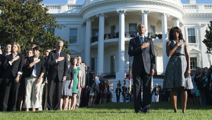 Le président américain Barack Obama et son épouse Michelle Obama observent une minute de silence dans les jardins de la Maison Blanche à Washington, le 11 septembre 2015