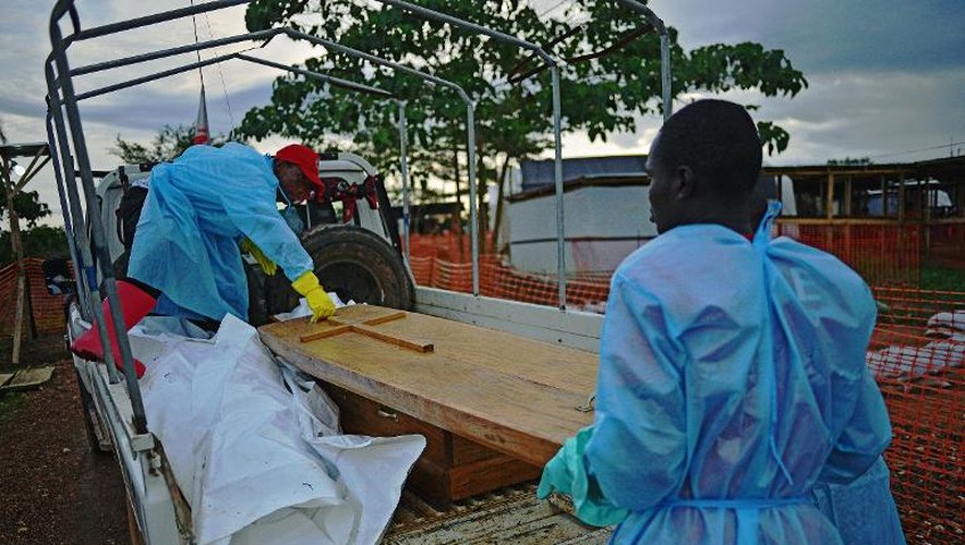 Le cercueil du docteur Modupeh Cole, médecin sierra-léonais décédé de la fièvre Ebola, aux côtés de deux corps enveloppés dans des sacs, le 14 août 2014 dans le centre de Médecins sans Frontières (MSF) à Kailahun, dans l'est du pays