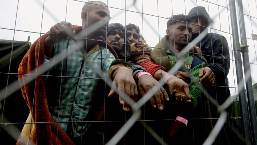 Des migrants pakistanais montrent leurs bracelets à code-barres dans un camp de réfugiés à la frontière serbo-hongroise, près du village de Roszke, le 11 septembre 2015