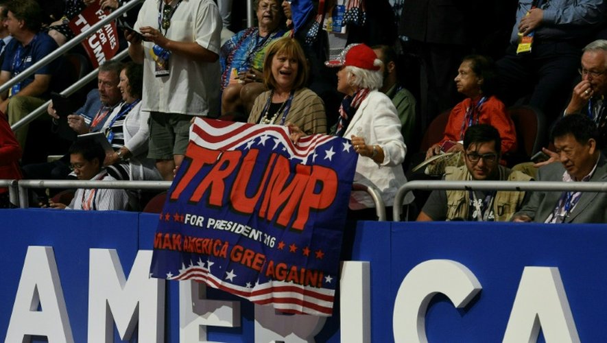 Des délégués républicains brandissent une banderole de soutien à Donald Trump le 22 juillet 2016 à Cleveland (Ohio)