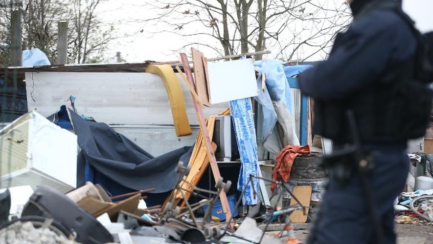 Un policier surveille un campement de roms après son évacuation par la police, le 27 novembre 2013, à Saint-Ouen, dans la banlieue parisienne