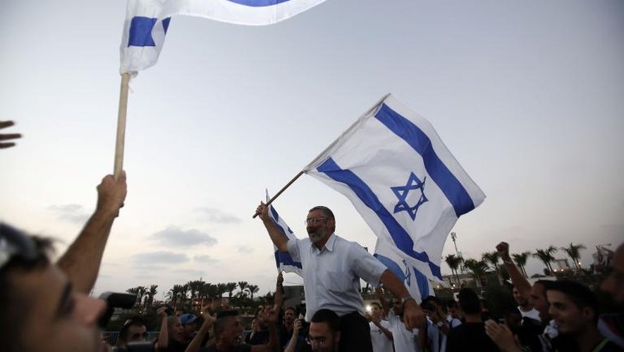 Des partisans de l'organisation d'extrême-droite israélienne, Lehava, agitent le drapeau israélien pour protester contre le mariage de Morel Malcha, juive reconvertie et Mahmoud Mansour, musulman, à Rishon LeZion le 17 août 2014
