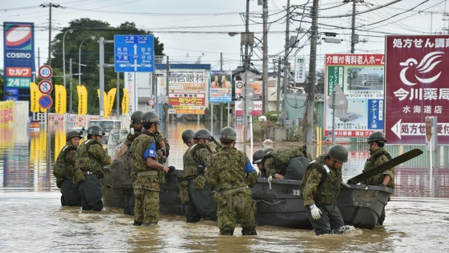 Des membres des secours évacuent des habitants de la ville de Joso où la rivière Kinugawa est violemment sortie de son lit, le 12 septembre 2015 au Japon