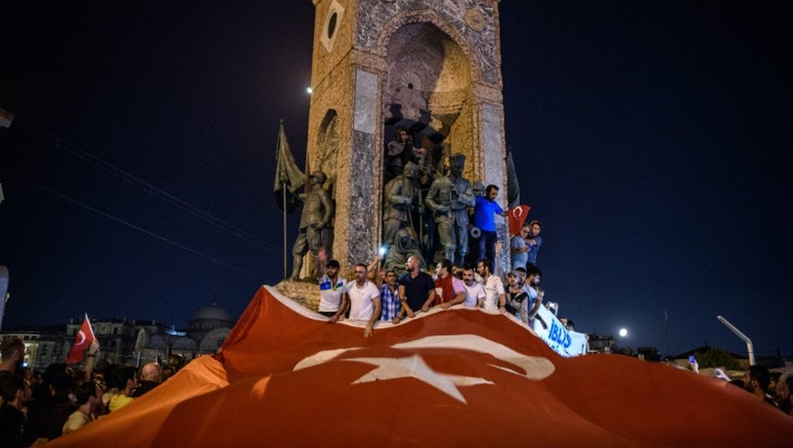 Des manifestants agitent un immense drapeau turc sur la place Taksim, à Istanbul, le 16 juillet 2016