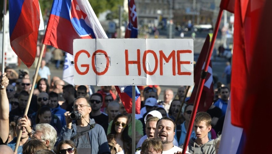 Des manifestants arborent des drapeaux et une banderole "Rentrez chez vous" pendant un rassemblement à l'initiative d'un groupe appelé "Arrêtez l'islamisation de l'Europe" à Bratislava, en Slovaquie, le 12 septembre 2015