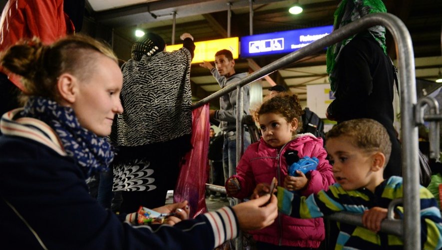 Une femme donne des chocolats à des enfants migrants arrivés le 11 septembre 2015 à Munich en provenance de Budapest