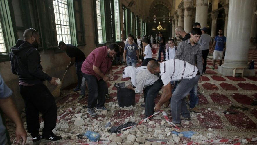 Des Palestiniens nettoient la mosquée d'Al-Aqsa après les heurts ayant opposé des musulmans aux forces de l'ordre israéliennes, le 13 septembre 2015 à Jérusalem