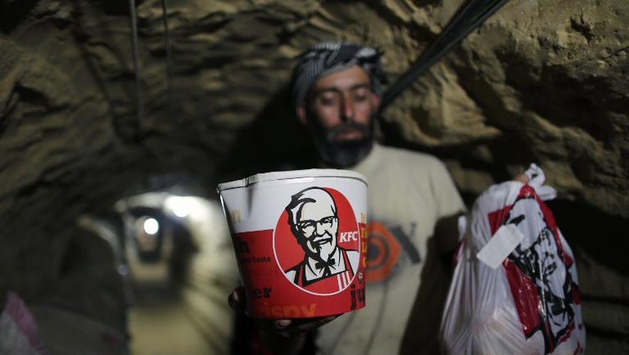 Un homme transporte de la nourriture de la chaîne KFC dans un tunnel entre la bande de Gaza et l'Egypte, le 13 mai 2013