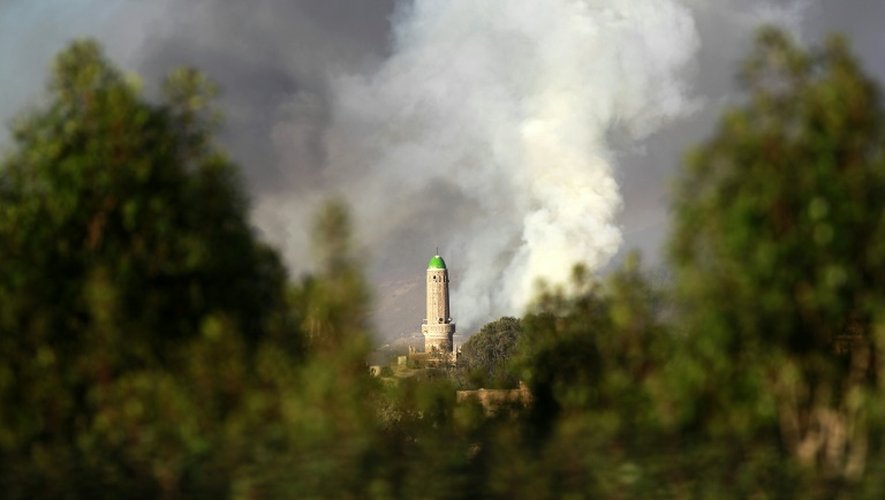 De la fumée au-dessus d'un dépôt d'armes, cible des frappes aérienne de la coalition arabe, le 11 septembre 2015 à Sanaa