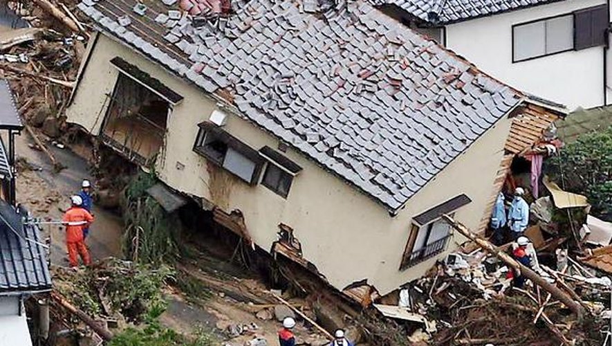Des sauveteurs au milieu d'habitations détruites lors d'un glissement de terrain le 20 août 2014 à Hiroshima