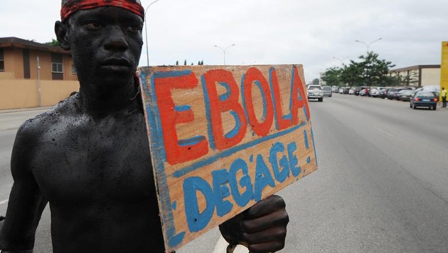 Un homme tient une pancarte "Ebola dégage" à l'occasion d'une marche de sensibilisation de la population au virus Ebola, le 19 août 2014 à Abidjan en Côte d'Ivoire