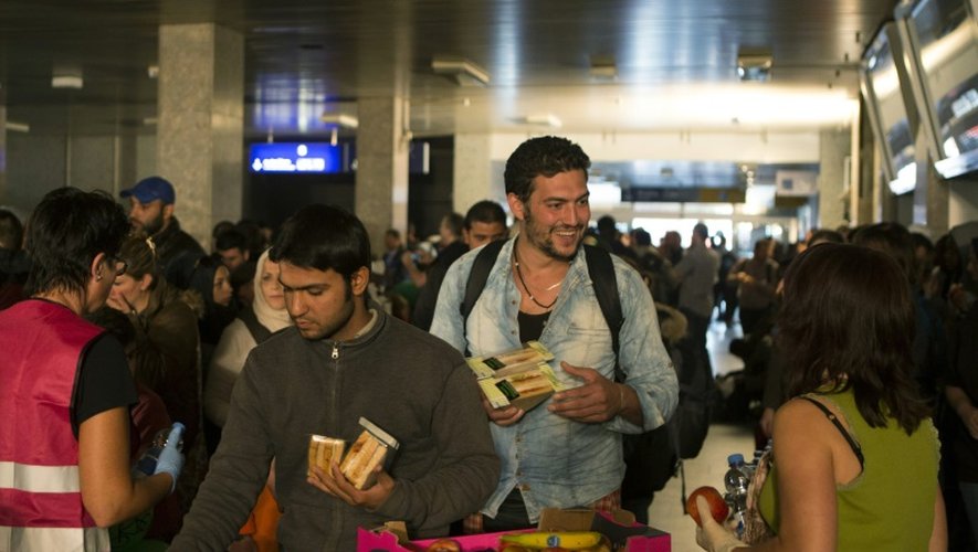 Des réfugiés reçoivent de la nourriture et de l'eau à leur arrivée à Berlin, à bord d'un train spécial affrété à Munich, le 13 septembre 2015