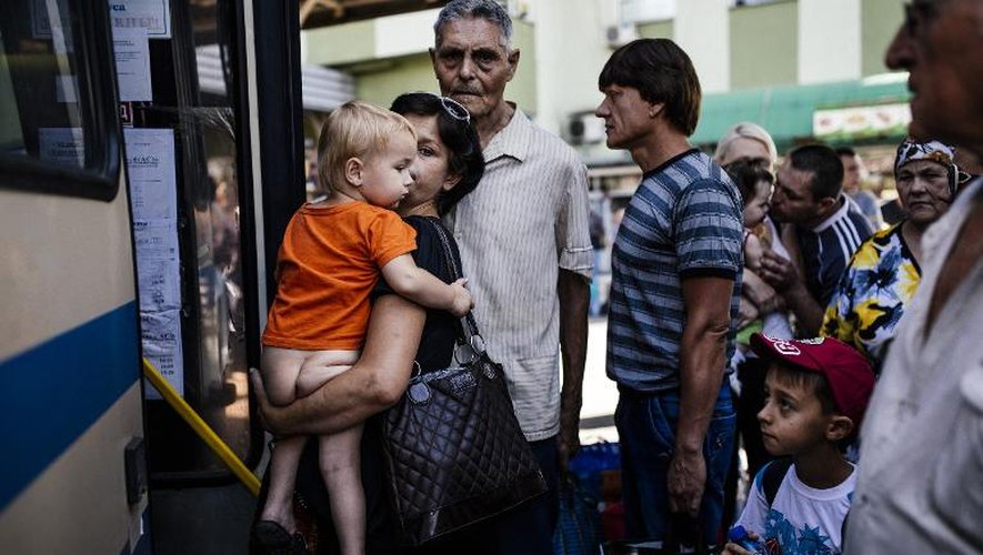 Une mère et son enfant montent dans un autobus à Donetsk où les combats s'intensifient, le 20 août 2014