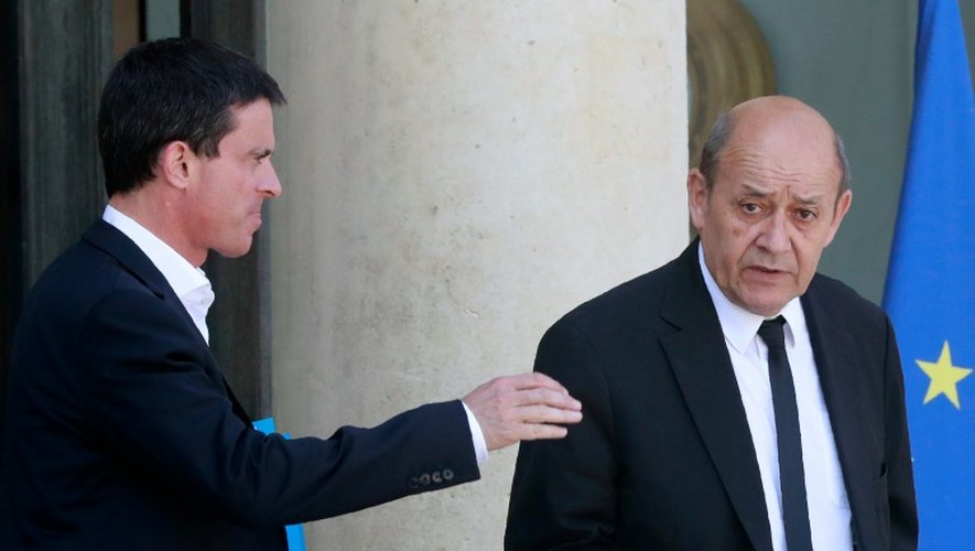 Manuel Valls (g) et le ministre de la Défense Jean-Yves Le Drian quittent l'Elysée après un séminaire gouvernemental, le 23 juillet 2016