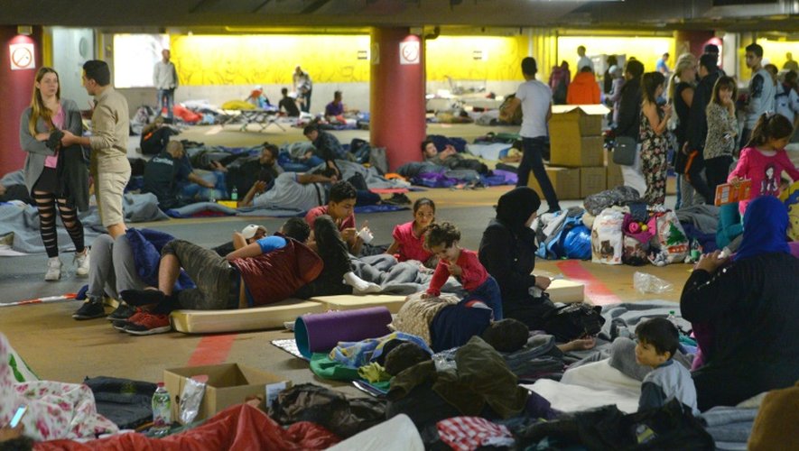 Des familles de migrants se reposent dans le parking de la gare le 13 septembre 2015 à Salzbourg