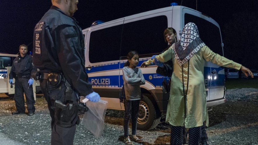 Une famille de migrants contrôlée par des policiers le 14 septembre 2015 près de Piding au sud de l'Allemagne à la frontière avec l'Autriche
