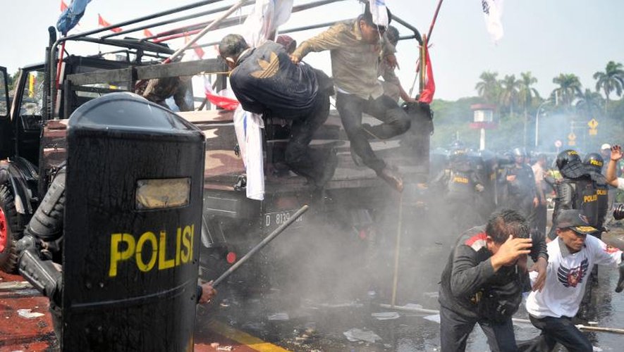 La police anti-émeute face aux supporters du candidat perdant à la présidentielle, Prabowo Subianto, tentant de passer à travers un barrage près de la Cour constitutionnelle à Jakarta le 21 août 2014