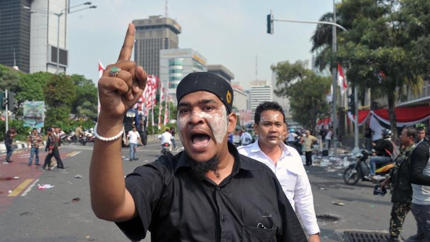Un supporter du candidat perdant à la présidentielle, Prabowo Subianto, crie des slogans alors que la police tente de disperser la foule à un barrage près de la Cour constitutionnelle à Jakarta le 21 août 2014