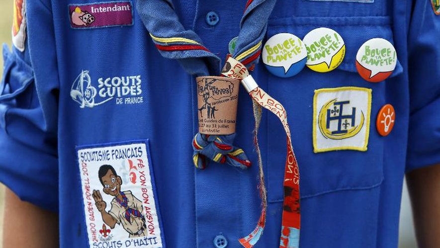Un jeune scout arbore ses insignes le 30 juillet 2012 lors d'un jamboree, au château de Jambville, dans les Yvelines