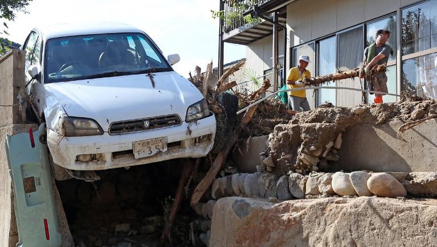Des habitants déblaient les décombres suite aux glissements de terrain à Hiroshima le 21 août 2014