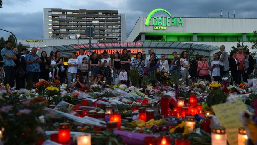 Des gens se recueillent près du centre commercial Olympia-Einkaufszentrum, en hommage aux victimes de la fusillade, le 24 juillet 2016 à Munich