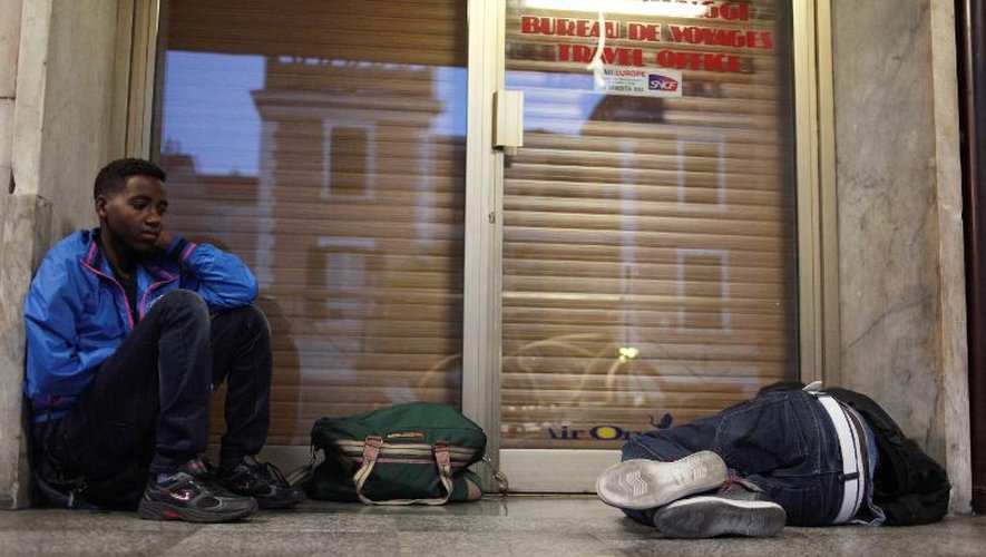 Des migrants se reposent dans la gare de Vintimille en Italie le 6 aout 2013, juste avant de passer la frontière pour aller en France