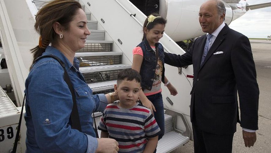 Le ministre des affaires étrangères Laurent Fabius accueille une quarantaine de réfugiés chrétiens irakiens à l'aéroport de Roissy Charles de Gaulle, le 21 août 2014