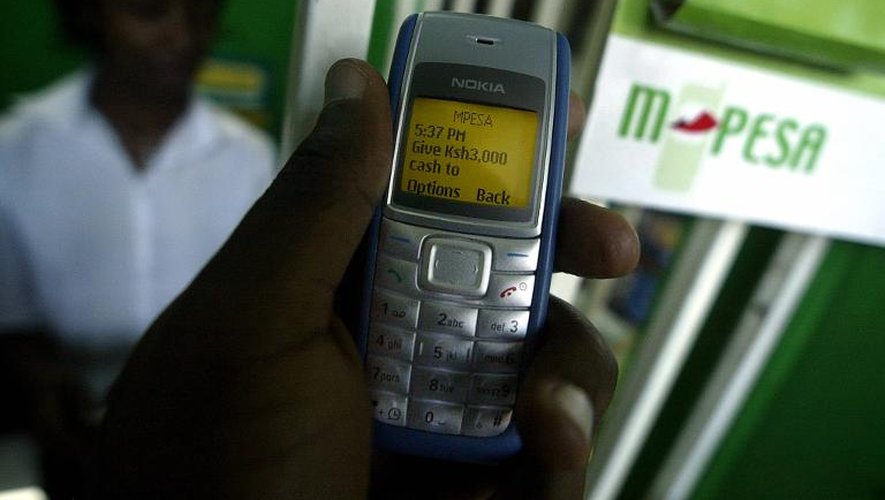 Un homme utilise le système M-Pesa pour transférer de l'argent via son téléphone mobile