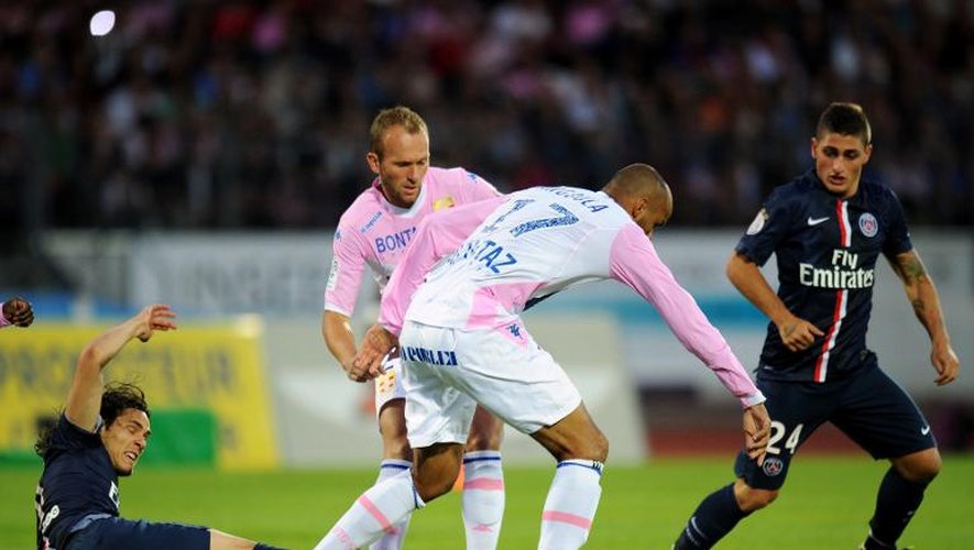 L'attaquant uruguayen du Paris SG Edinson Cavani tacle le défenseur français d'Evian-Thonon-Gaillard Aldo Angoula lors d'un match de L1 entre les deux équipes, le 22 août 2014 à Annecy.