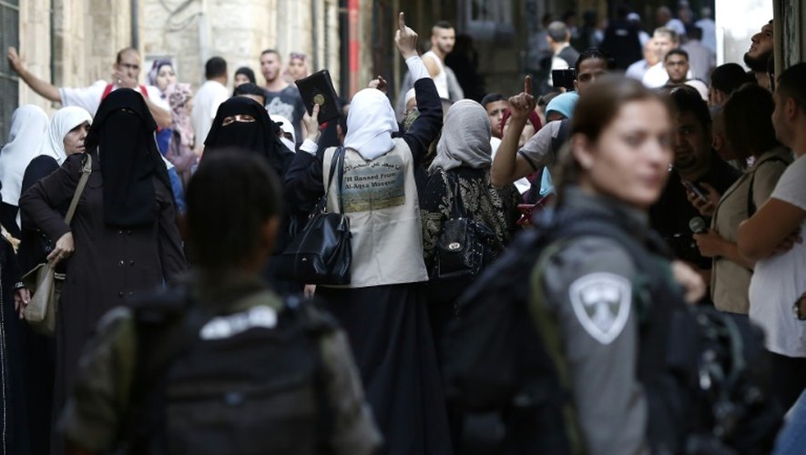 Des manifestants palestiniens crient des slogans face aux forces de sécurité israéliennes le 15 septembre 2015 à Jérusalem