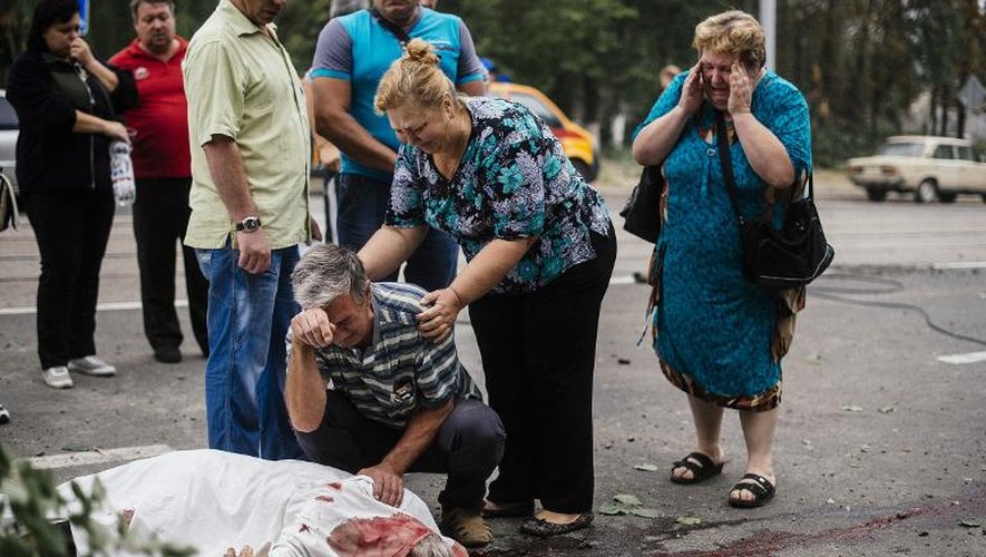 Le corps ensanglanté d'un homme tué lors de bombardements gît le 23 août 2014 dans une rue de Donetsk