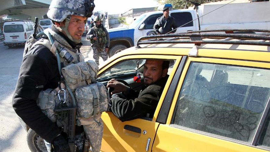 Un policier irakien contrôle une voiture à Bagdad, le 16 décembre 2013