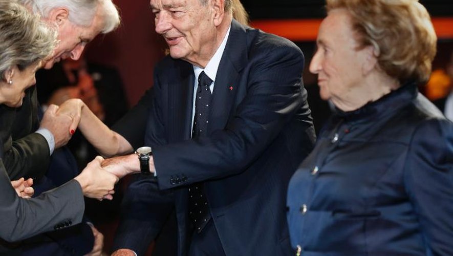 L'ancien président Jacques Chirac et son épouse Bernadette saluent des invités à leur arrivée à la cérémonie de remise du Prix de la Fondation Chirac, au musée du Quai Branly à Paris, le 21 novembre 2013
