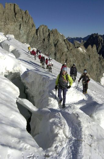 Des jeunes escaladent avec un guide le Dôme des Ecrins dans les Alpes françaises le 5 juillet 2003