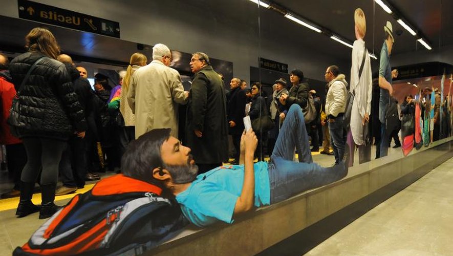 Des gens passent devant des miroirs créés par l'artiste italien Michelangelo Pistoletto dans le métro de Naples, le jour de leur inauguration le 2 décembre 2013