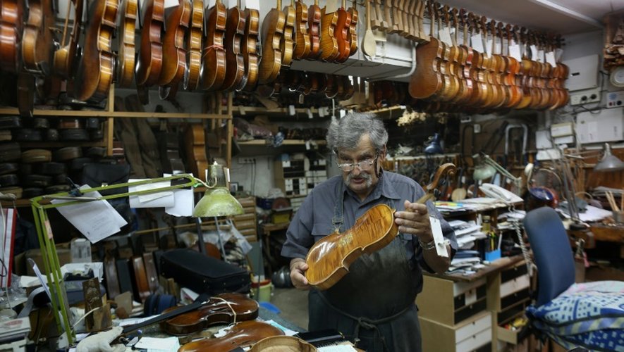 Amnon Weinstein, 76 ans montre sa collection de violons restaurés dans son atelier de Tel Aviv, le 15 juillet 2016